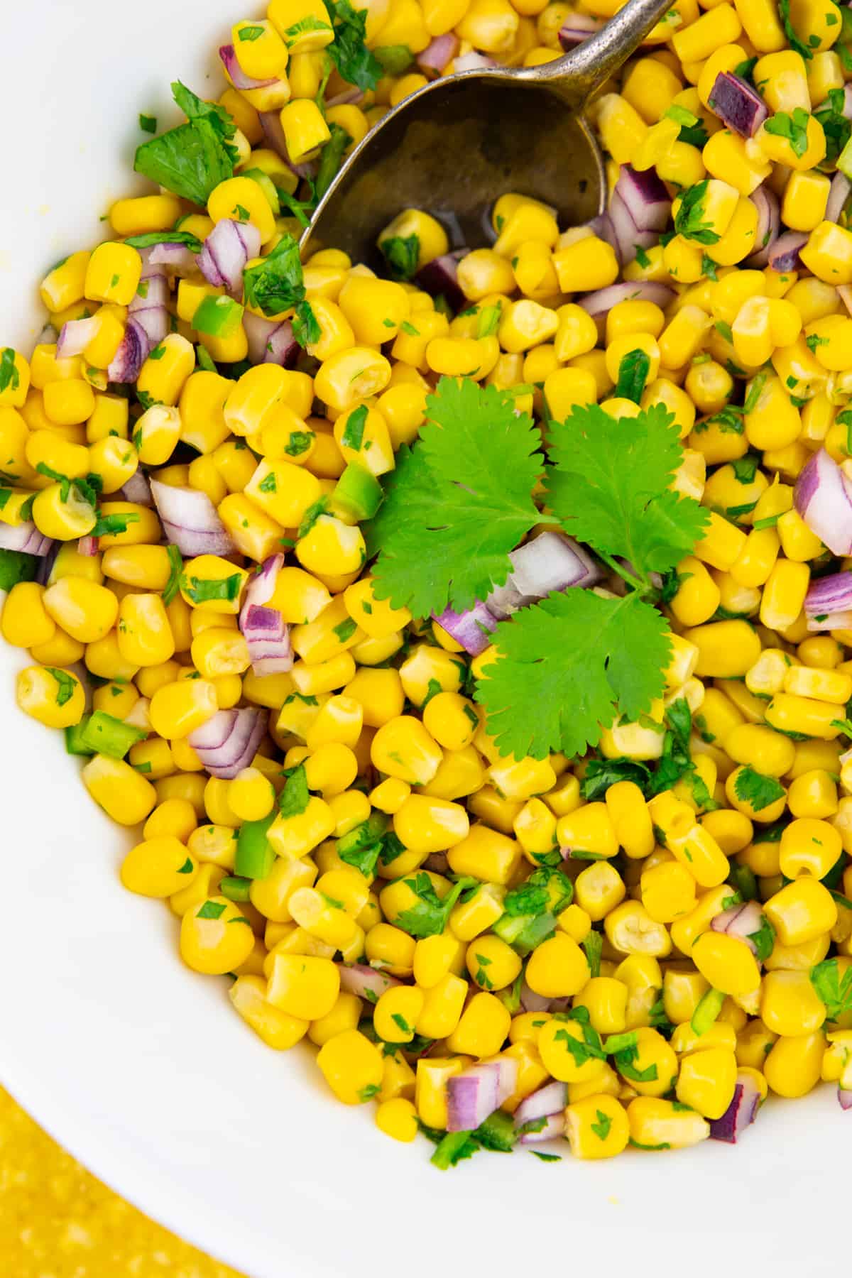 close-up of Chipotle corn salsa in a white bowl topped with fresh cilantro