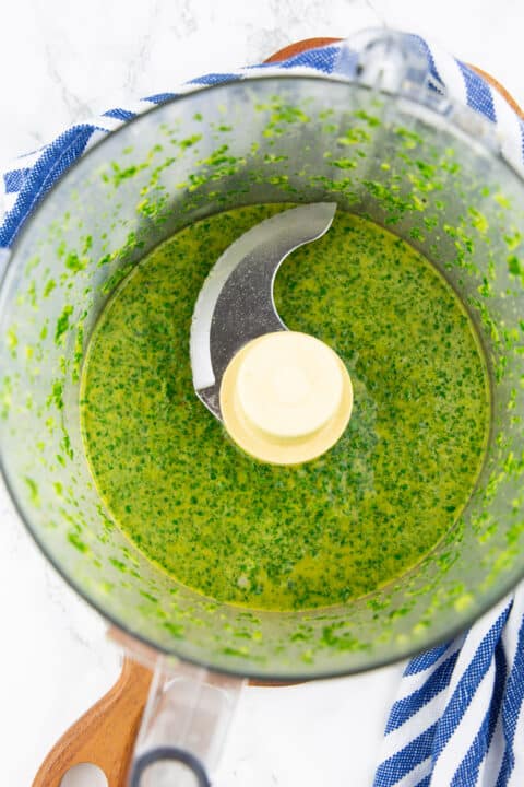 cilantro lime dressing in a food processor on a marble countertop