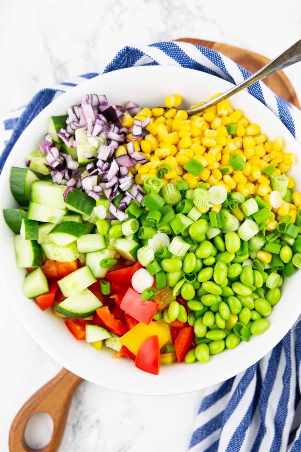 the ingredients for this salad in a white bowl with a spoon
