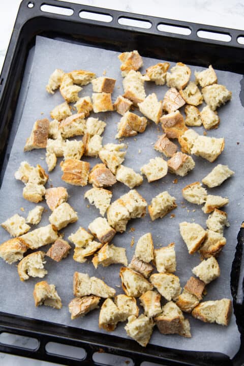 ciabatta cubes on a baking tray lined with parchment paper