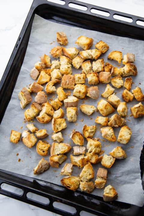 baked ciabatta cubes on a baking sheet lined with parchment paper