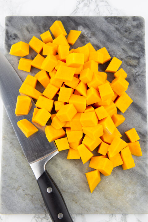 butternut squash cubes on a marble chopping board