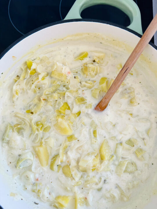 a pot with cooked potatoes, leek, and vegan cream cheese