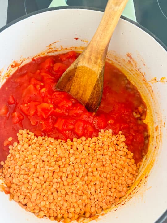 a white pot with diced tomatoes and red lentils