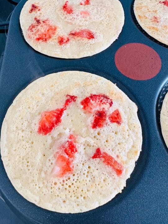 two strawberry pancakes on a pancake maker 