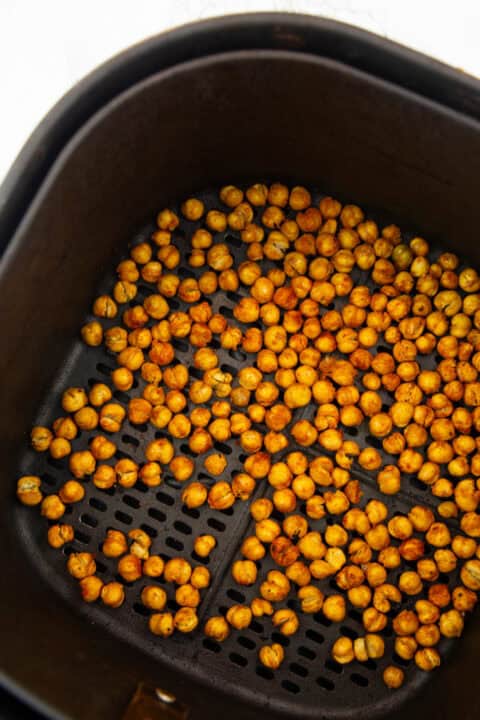 crispy chickpeas in a black air fryer basket on a marble countertop