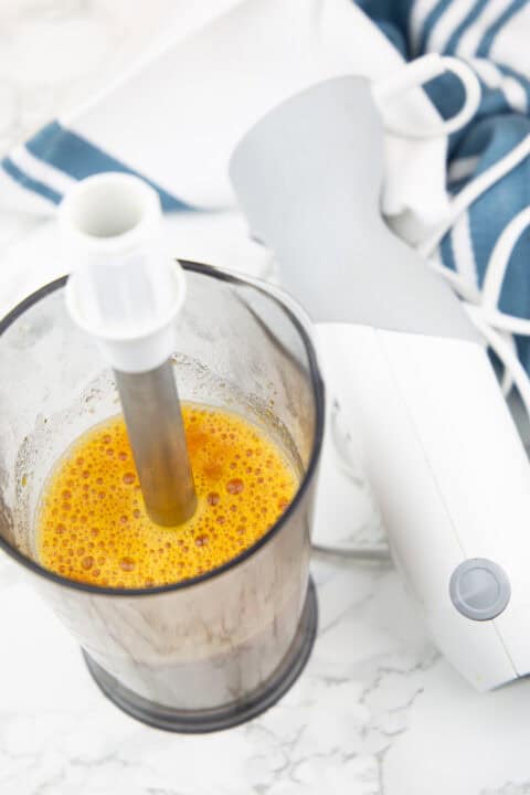 part of the vegan Tuscan white bean soup being blended with an immersion blender